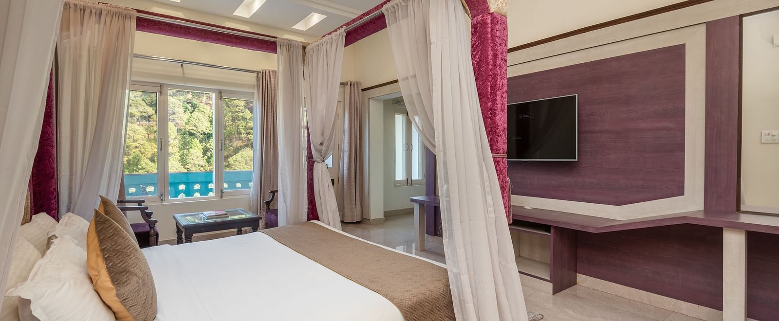 Luxurious bedroom at DLS Tehri Club Resort with a four-poster bed and elegant decor.